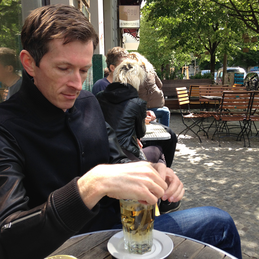 Man drinking tea in Paris street cafe.
