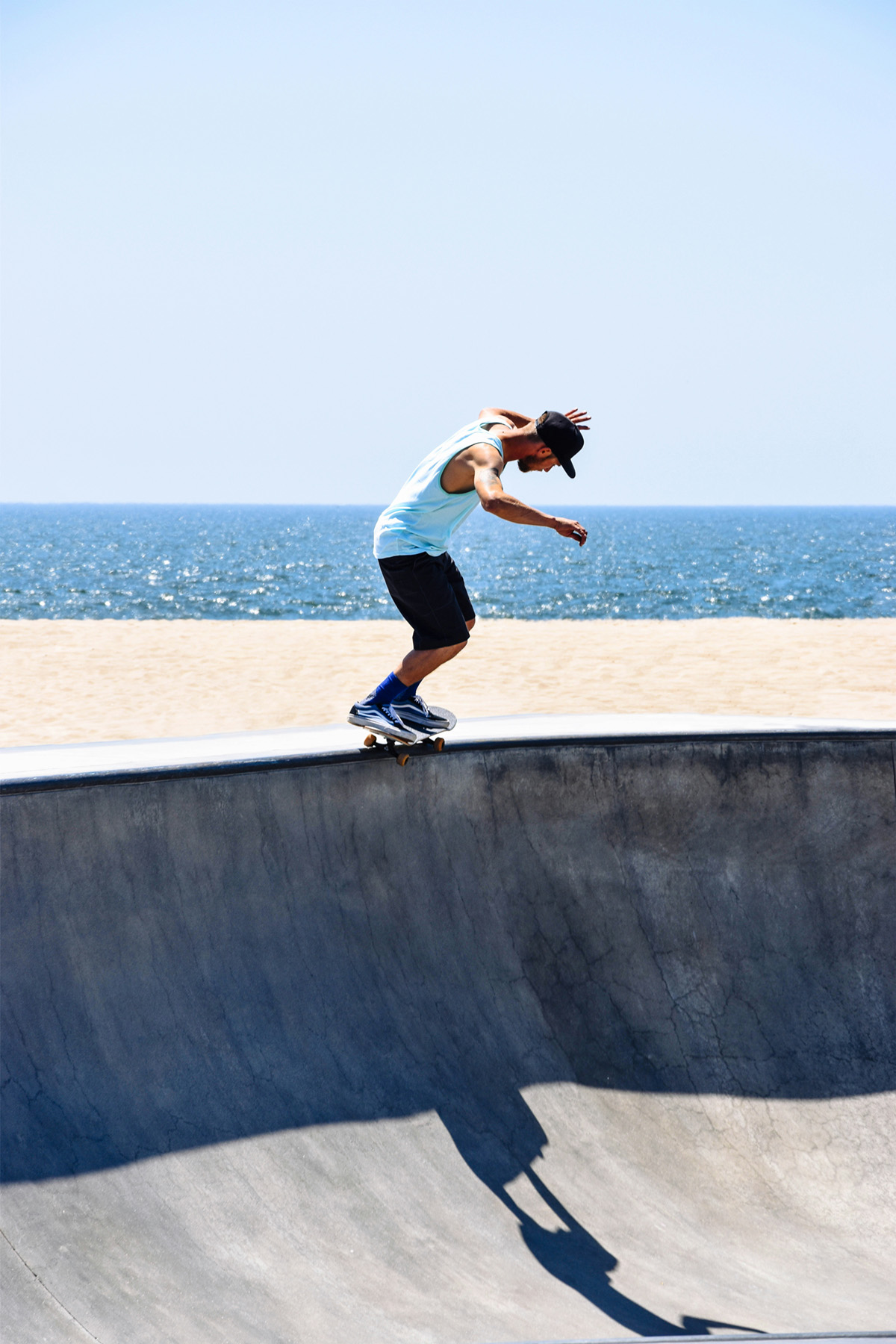 skateboarder on wall by the beach