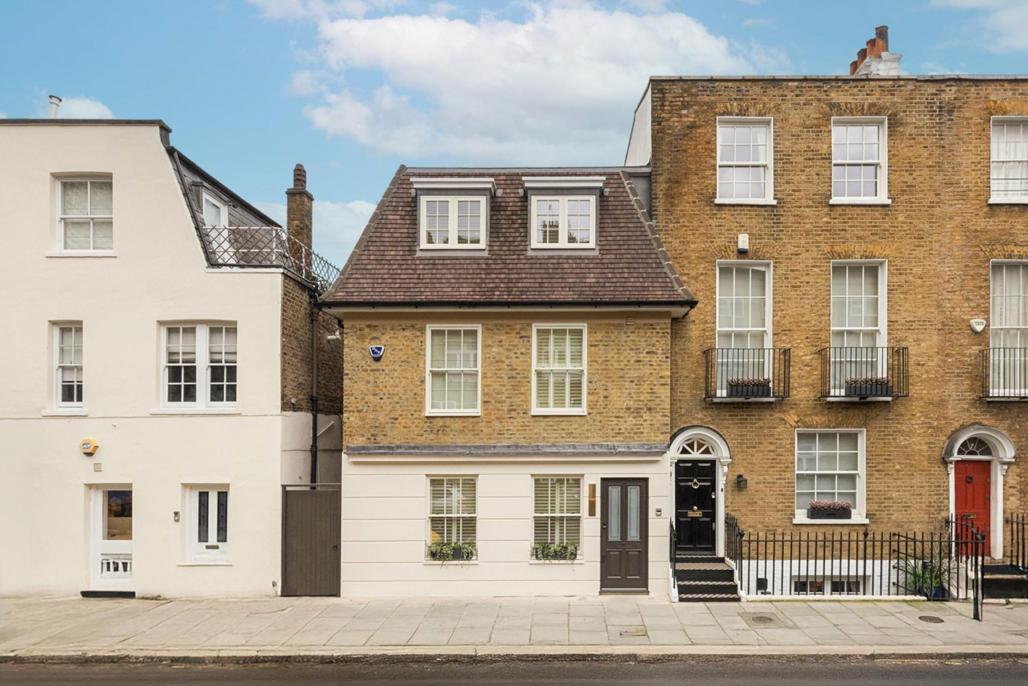 Exterior view of a Chelsea townhouse with a black door.