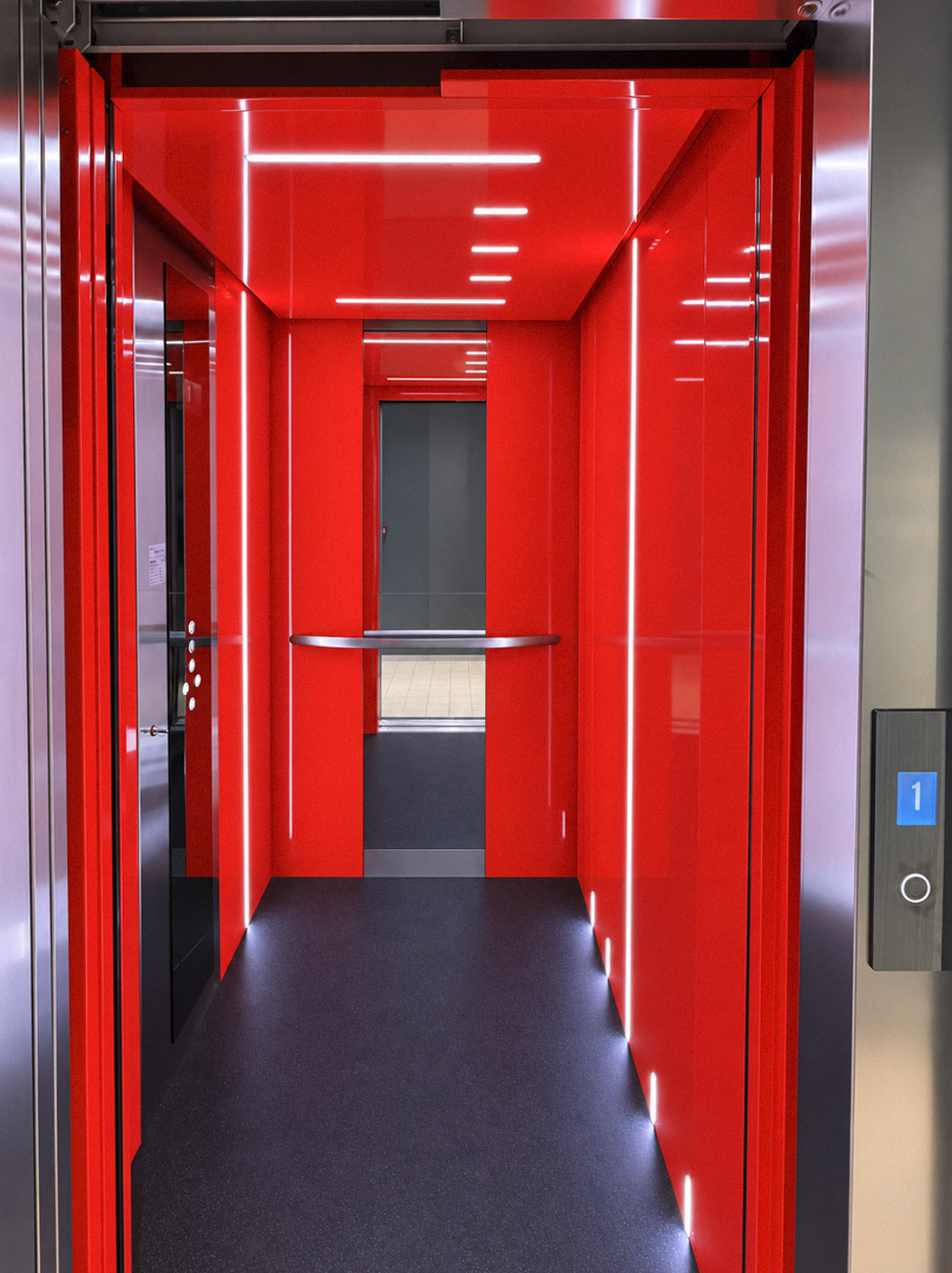Modern retail lift interior featuring glossy red walls and ceiling with linear white LED lights, a dark floor, metal handrail, mirror at the back, and stainless steel door frame with a digital floor indicator showing the number 1.