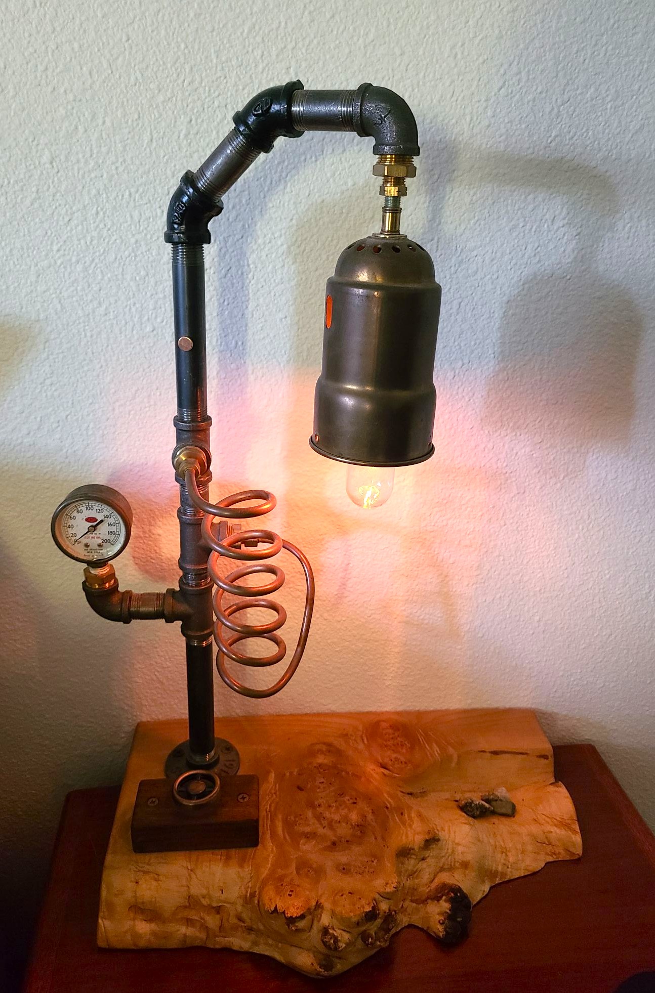 1/2" black iron pipe lamp with copper adjustable dimmer wheel, copper tubing and unique tool parts on 2" thick live edge maple burl base. 51" dark brown twisted cloth cord and plug. 40W Edison filament bulb.