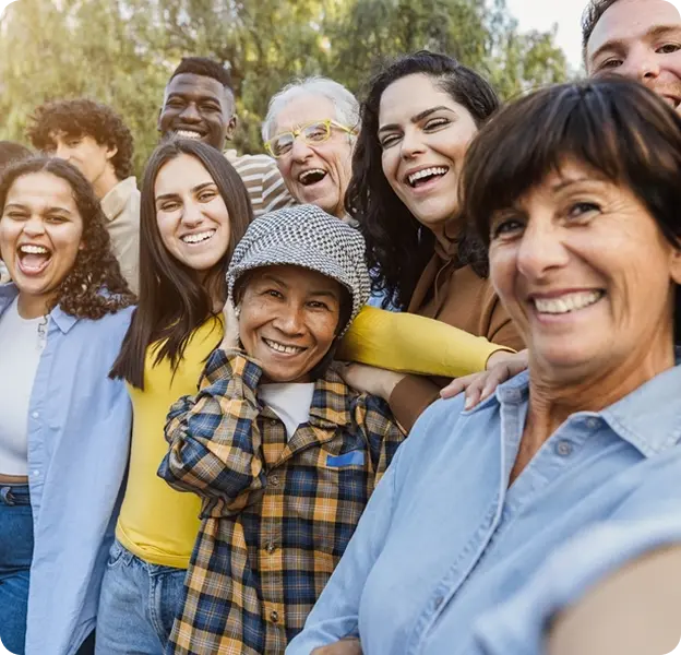 Group photo of cheerful people standing side by side in a park.webp
