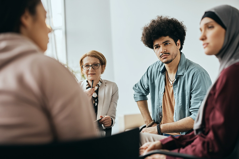 A multi-ethnic group huddled during a therapy session.