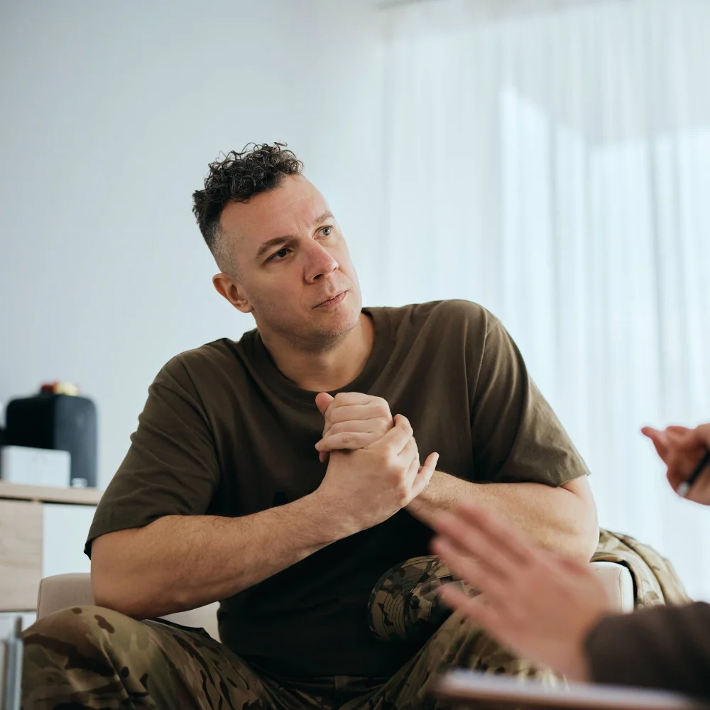 Veteran receiving trauma-informed counselling at The Hader Clinic, supported by an experienced therapist in a calm, professional setting