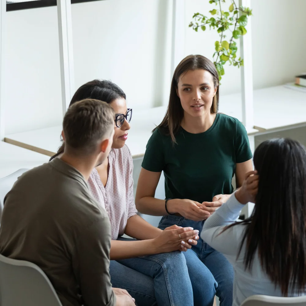 A family participating in a group therapy session, sharing experiences and receiving support for a loved one’s addiction recovery.