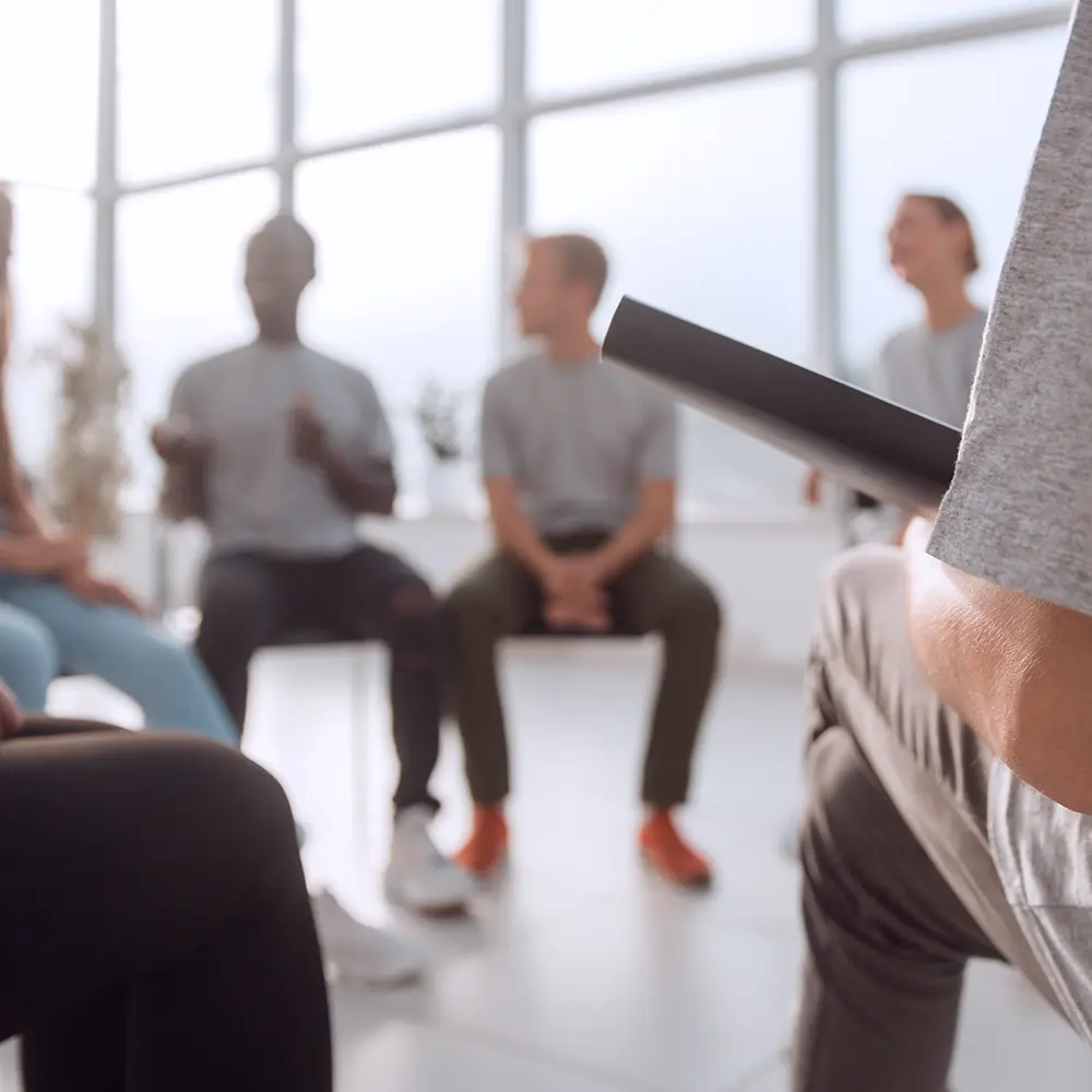 A diverse group of younger and older men and women in a group therapy session; there are two young women in the foreground. If you have private health insurance with Bupa, it may make residential rehab more accessible.