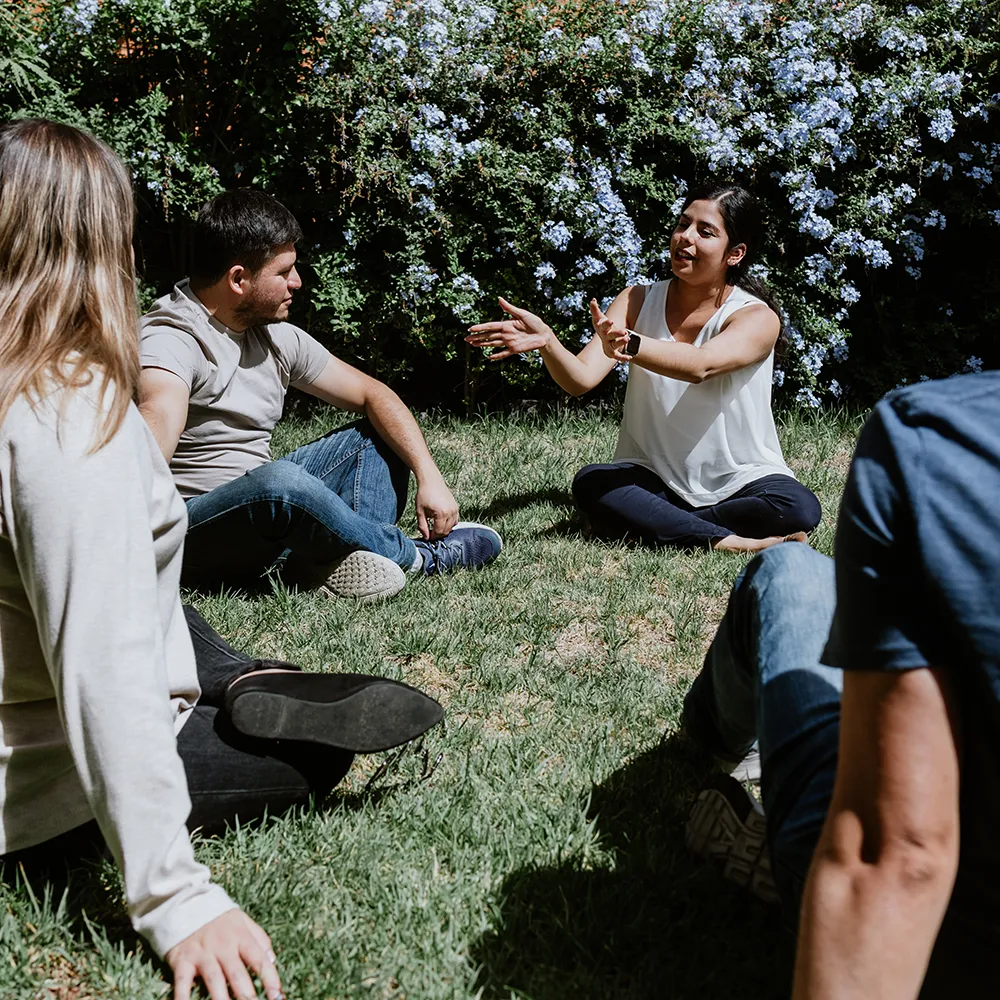 A diverse group of younger and older men and women in a group therapy session in the garden on a sunny day. If you have private health insurance with Bupa, it may make residential rehab more accessible.