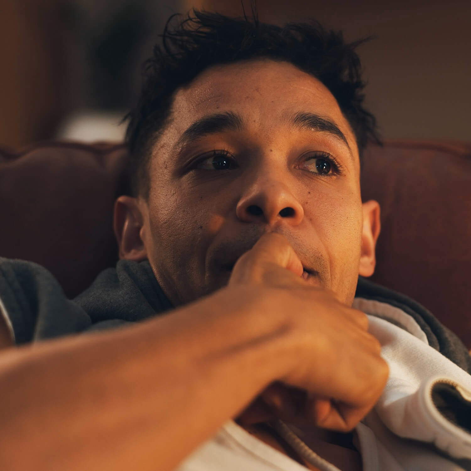 A man sits on a sofa at night, appearing anxious and withdrawn — illustrating the emotional challenges of ice addiction and the need for compassionate, professional rehab support.