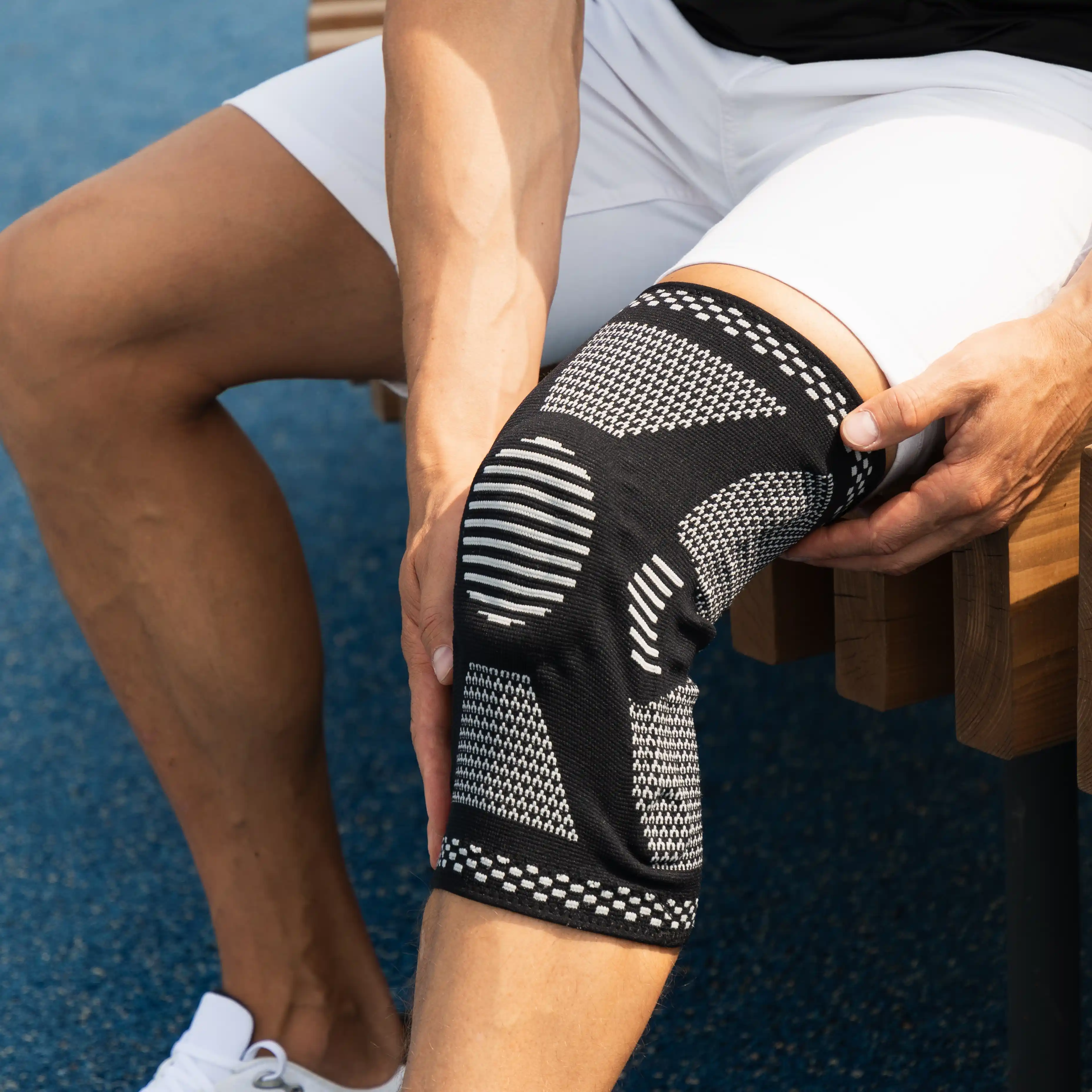 A man adjusts a knee brace for a sports injury, reflecting how pain from athletic injuries can lead to prescription drug use — and the risk of addiction requiring professional rehab support.