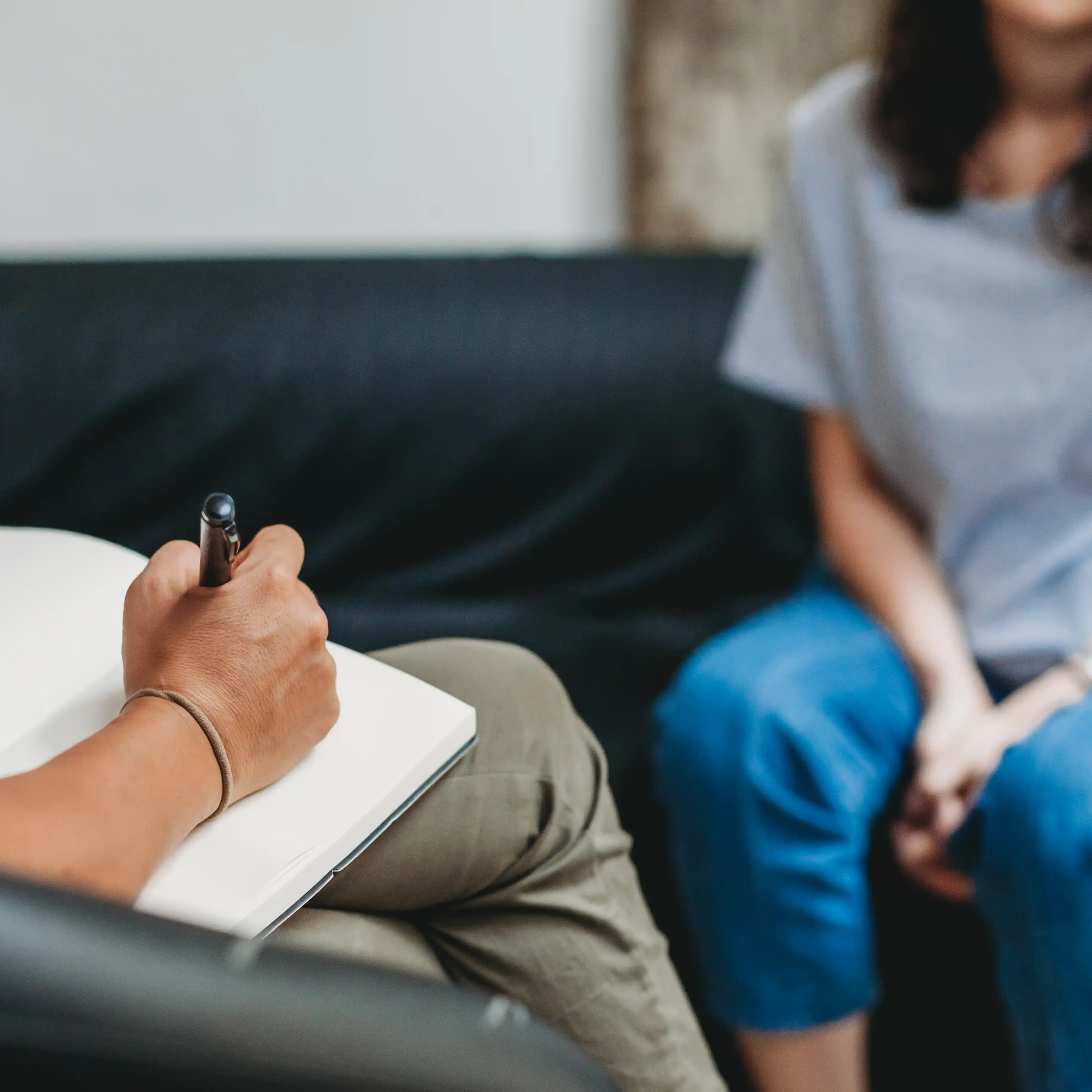 A woman speaks with a psychologist during a therapy session at The Hader Clinic, symbolising the safe, supportive care available for those recovering from addiction and domestic violence.