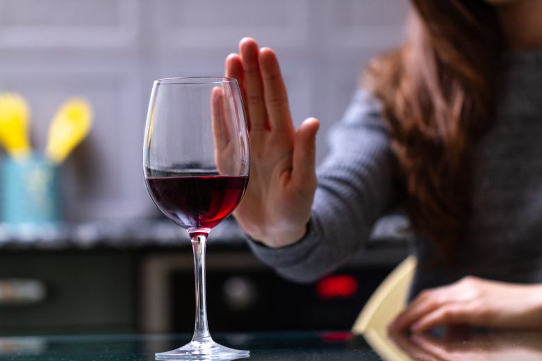 woman refusing a glass of wine