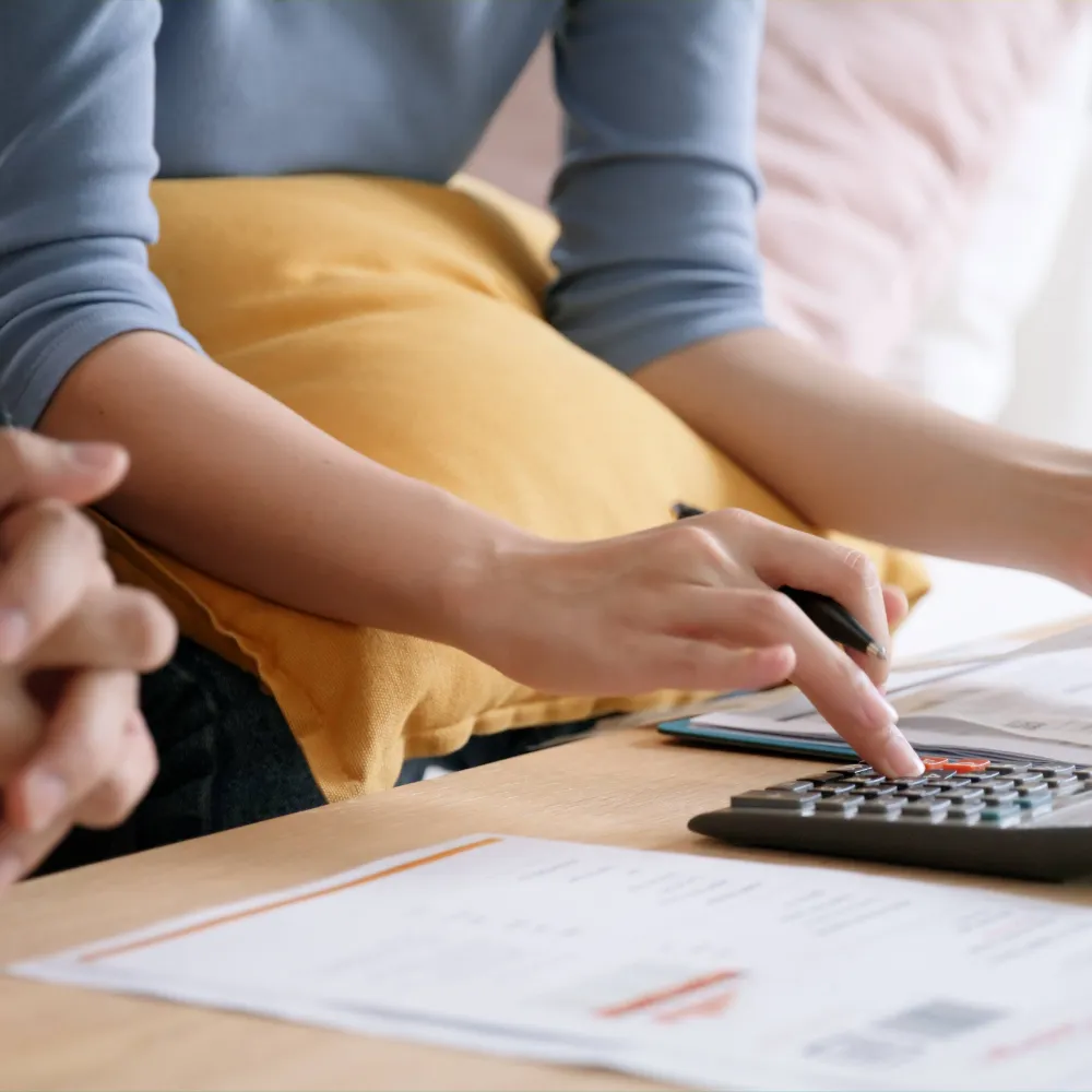 A closeup of the hands of a couple working out their finances with a calculator and a budgeting spreadsheet, to ensure they can afford a place in inpatient rehab. Even without Medicare, our funding options can make rehab much more accessible.