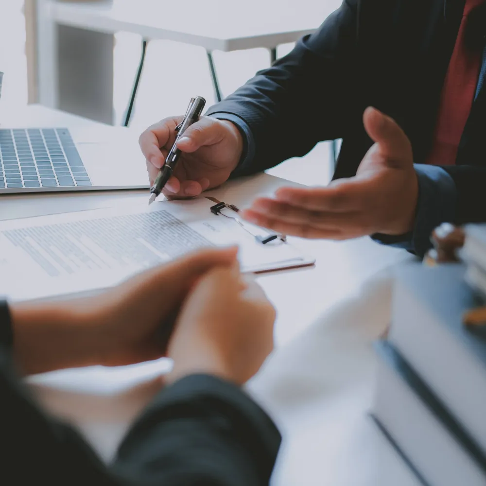 A closeup of the hands of a financial specialist and potential inpatient residents. They’re discussing financial assistance options for drug and alcohol rehab at The Hader Clinic.