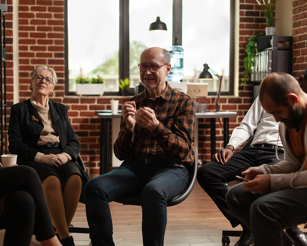 A senior sharing his addiction story during a group therapy session
