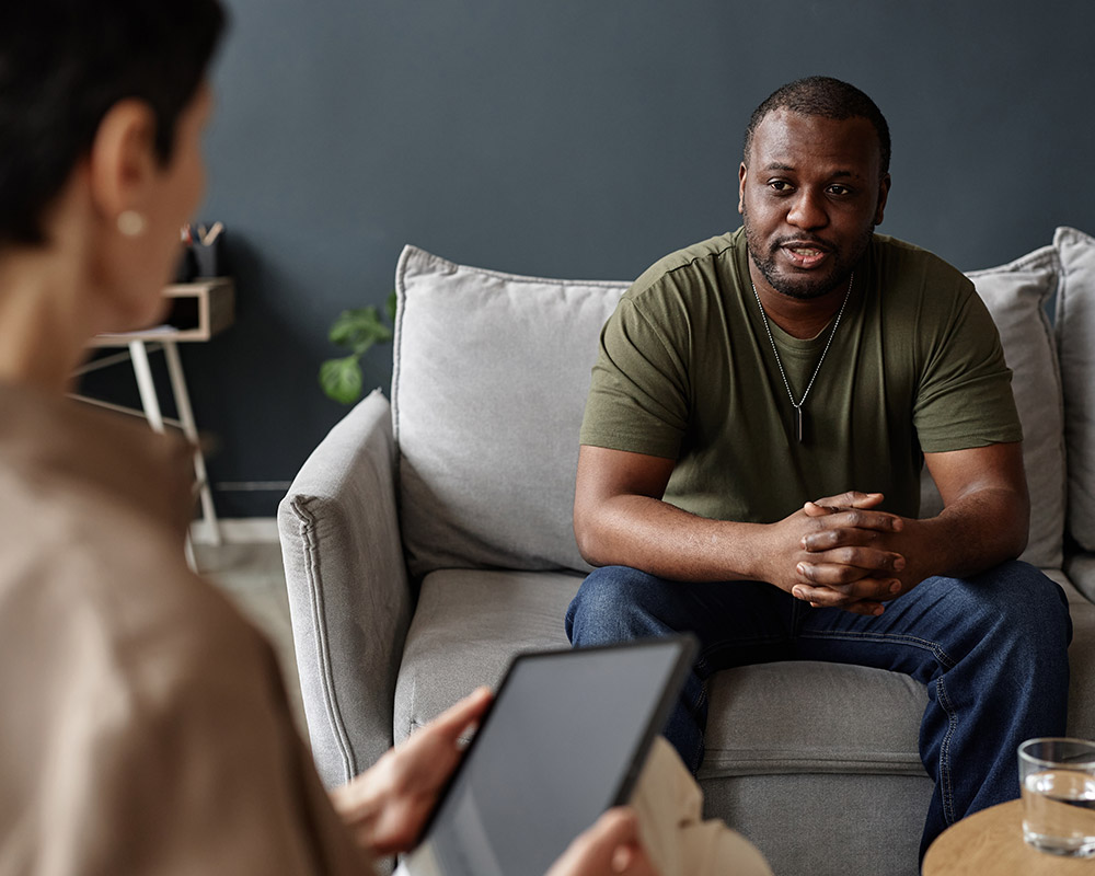 A portrait of a veteran seated with a therapist during an inpatient rehab session