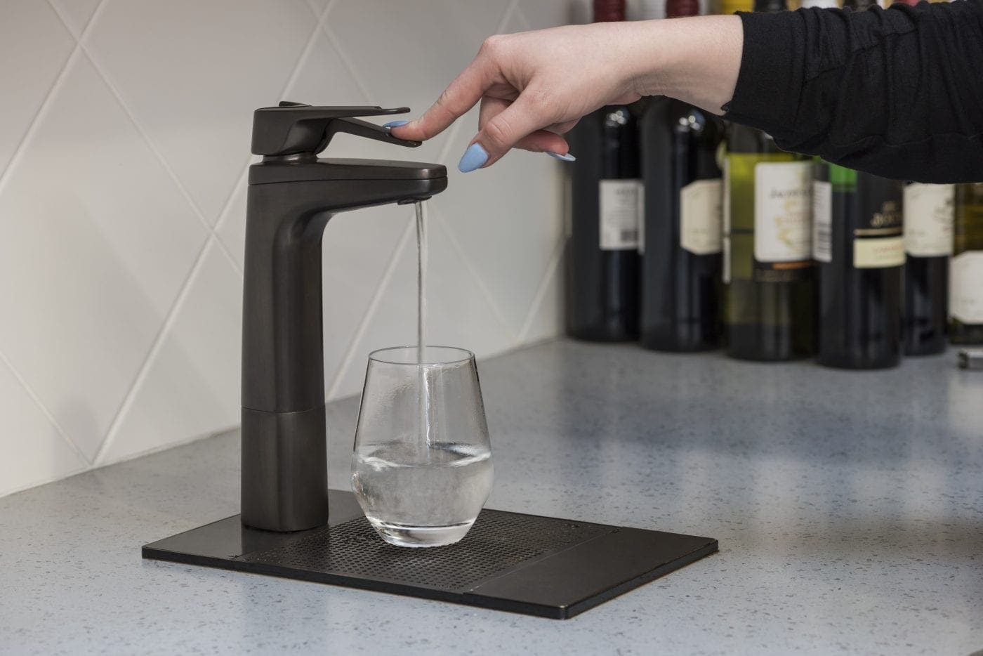 Matte black Billi XL levered dispenser filling a glass on a drip tray