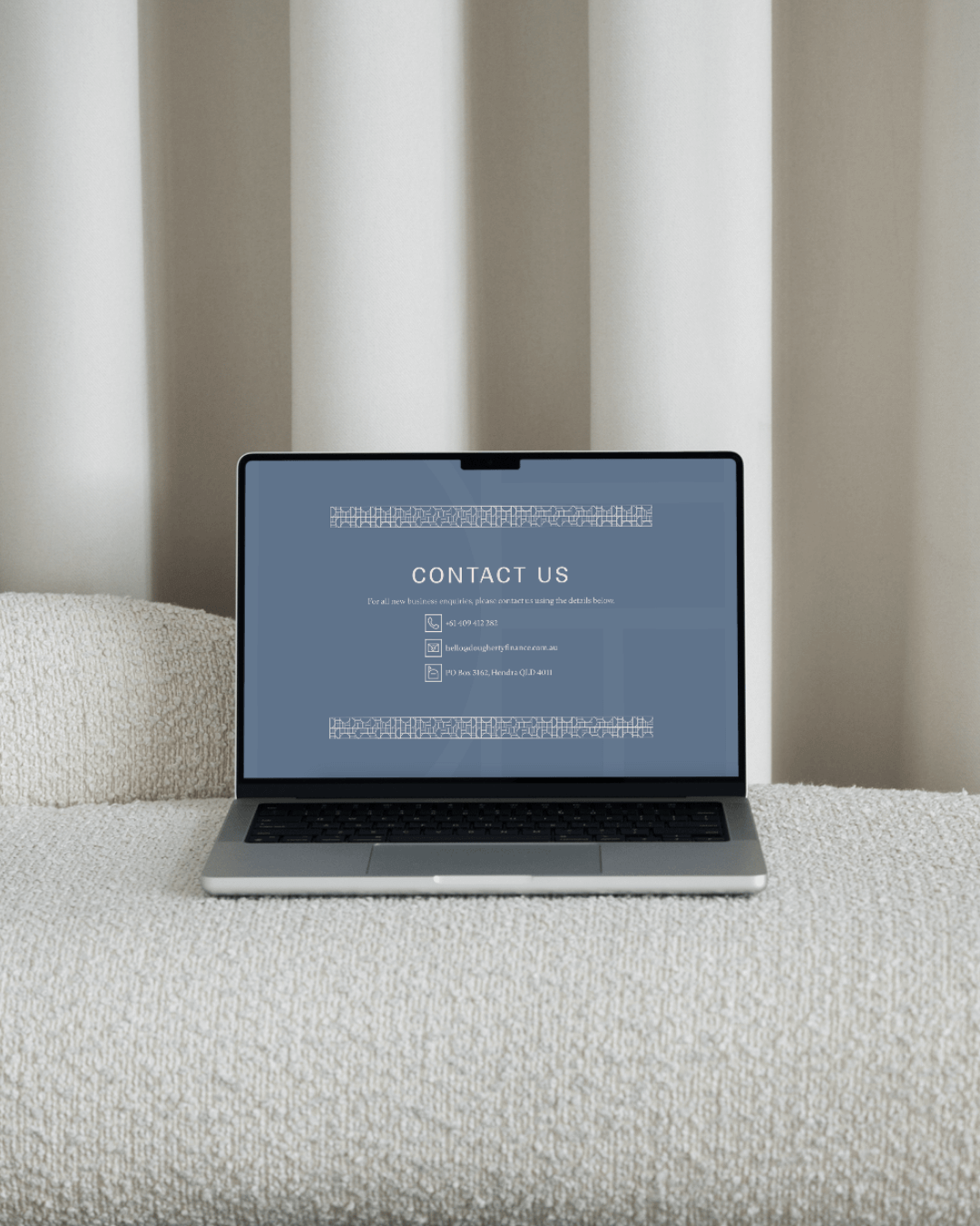Dougherty Finance website design by Lemon Street on an open laptop sitting on a grey couch