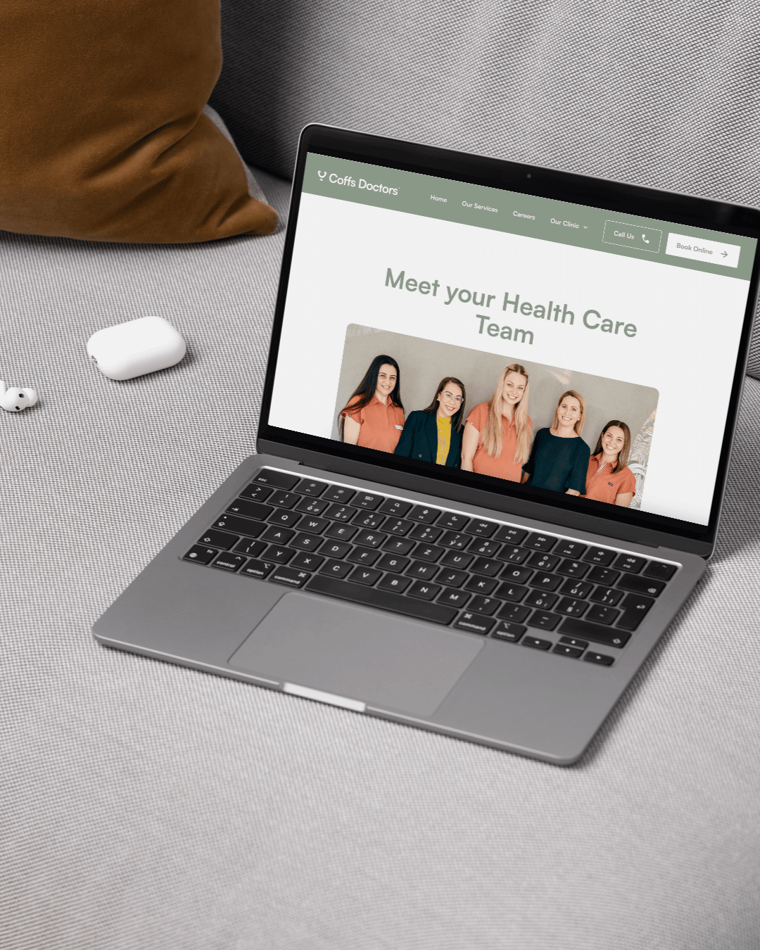 Coffs Doctors home page of the new website on a laptop sitting on a grey couch. Website designed by Lemon Street
