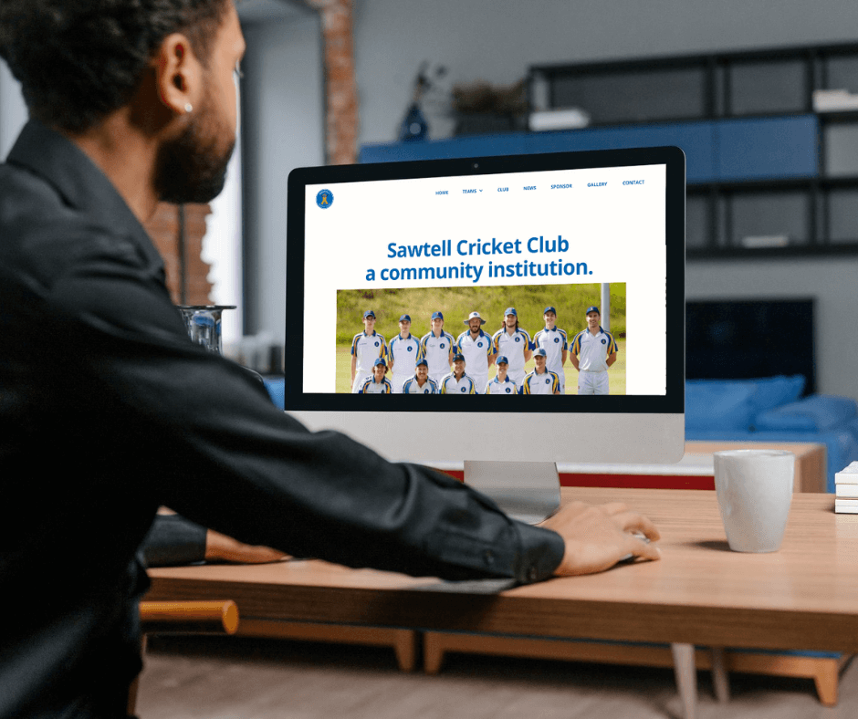 Man at desk looking at the home page of the Sawtell Cricket Club website on a desktop computer. Website design by Lemon Street. 