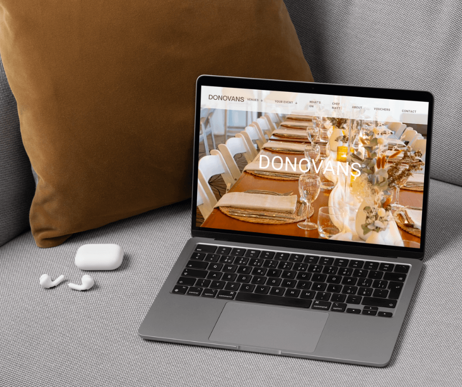 Donovan's Venues home page on a laptop sitting on a grey couch with a gold cushion. Website Design by Lemon Street