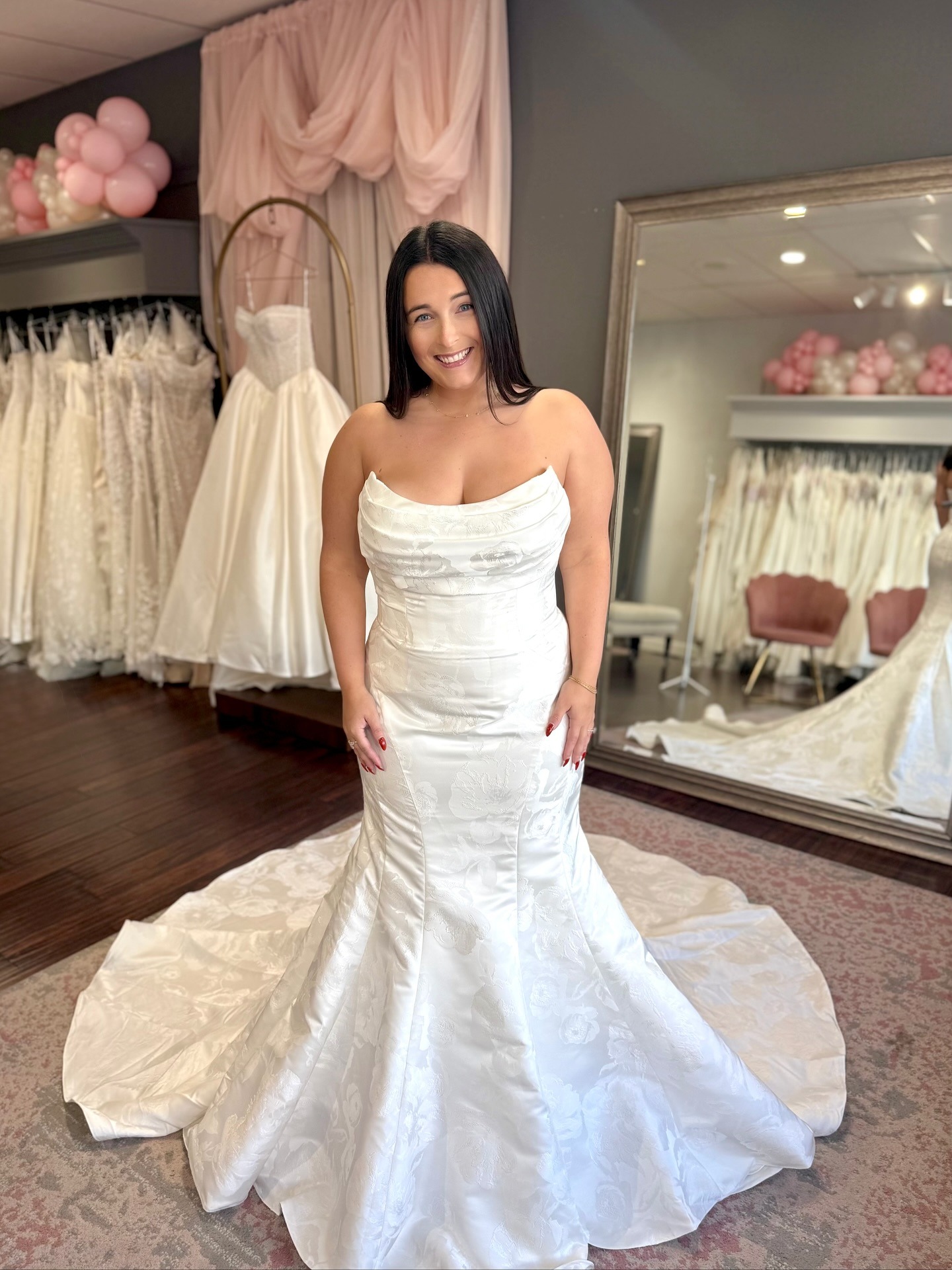 Plus-size wedding dress in Cincinnati: a model in a strapless ivory floral jacquard mermaid gown with a long train