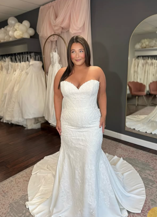 Model in a strapless sweetheart lace fit-and-flare wedding dress with a satin train at a Cincinnati bridal shop