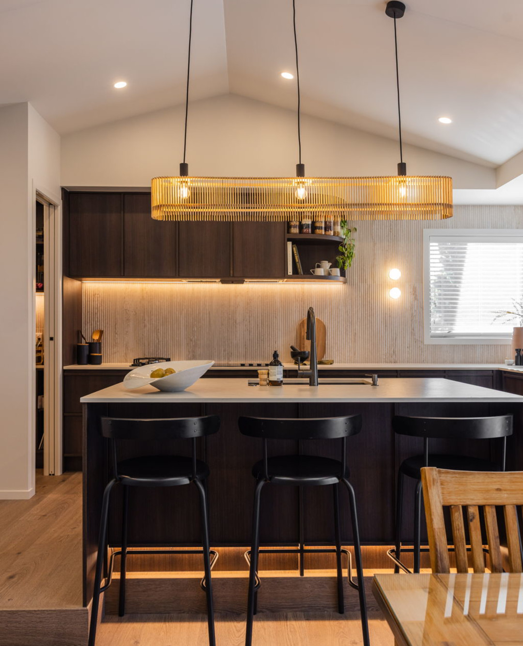 Come for the kitchen. Stay for the conversation. 🤎✨

Deep timber tones meet a ribbed splashback, softly curved shelving and a glowing state
