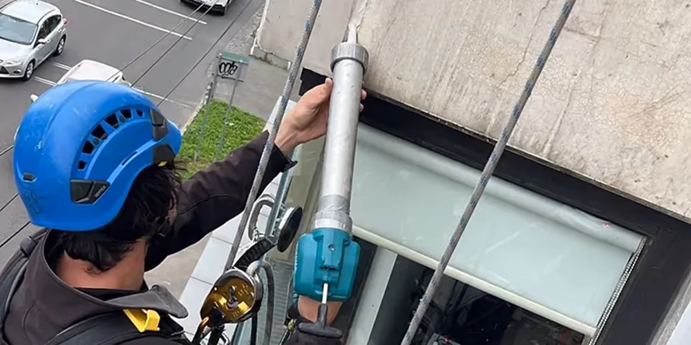 Rope access caulking on building