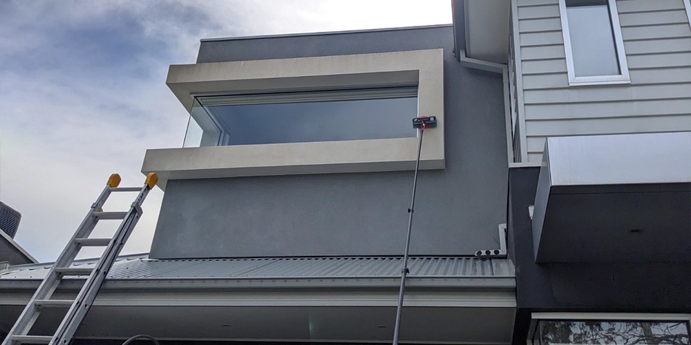 Cleaning a rendered exterior house wall with a soft wash treatment