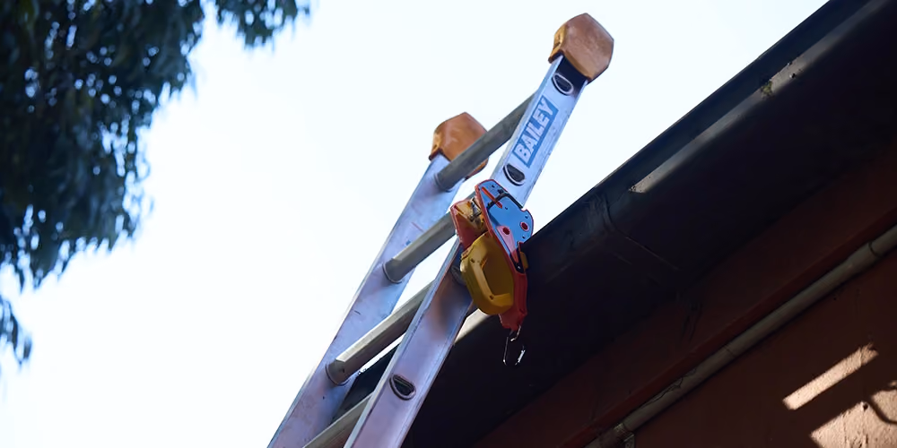 Safety anchor and ladder secured to the roofline during a gutter cleaning job in South Melbourne.