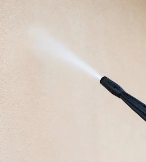 Controlled pressure washing used to remove graffiti from the painted wall surface.