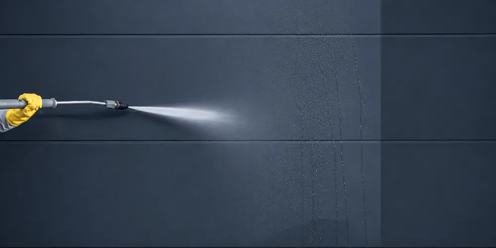Pressure washing removing surface marks from a dark exterior wall in Middle Park.