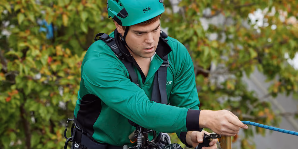 Safety-led gutter cleaners performing roof and gutter inspection at height.