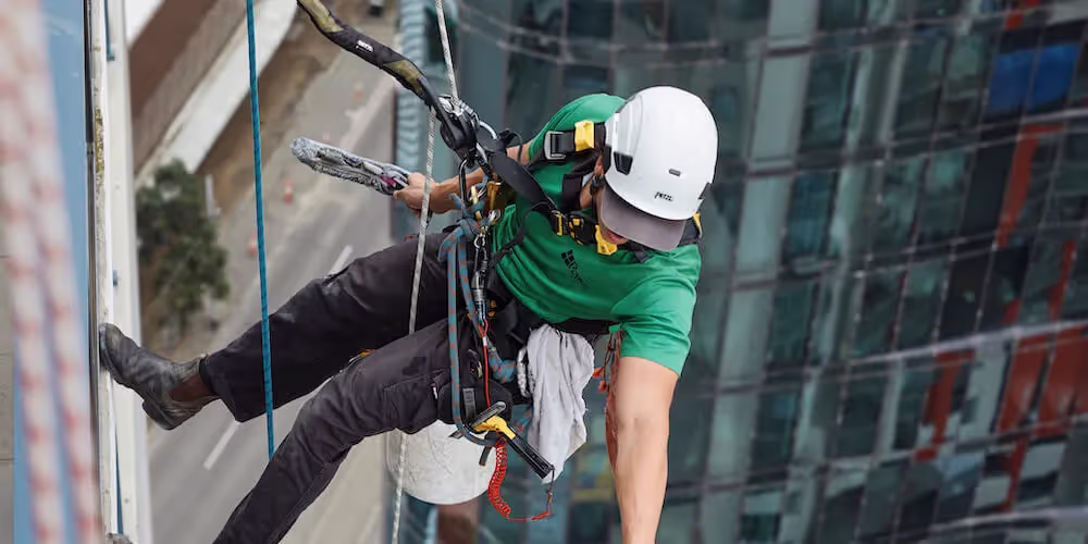 Rope access window cleaner safely working on high-rise commercial building.