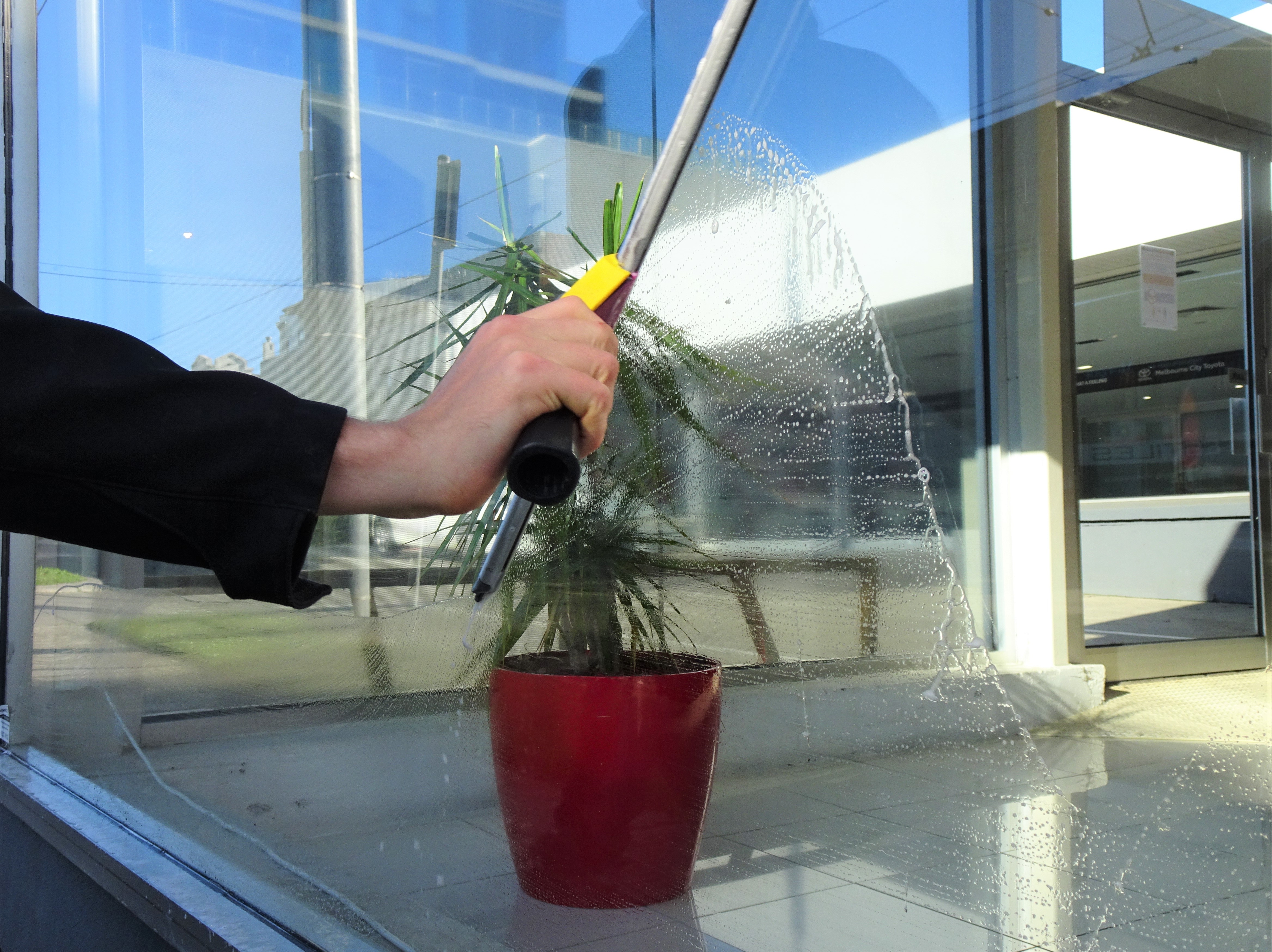 Bax Clean technician cleaning exterior windows on a Notting Hill property using professional equipment.