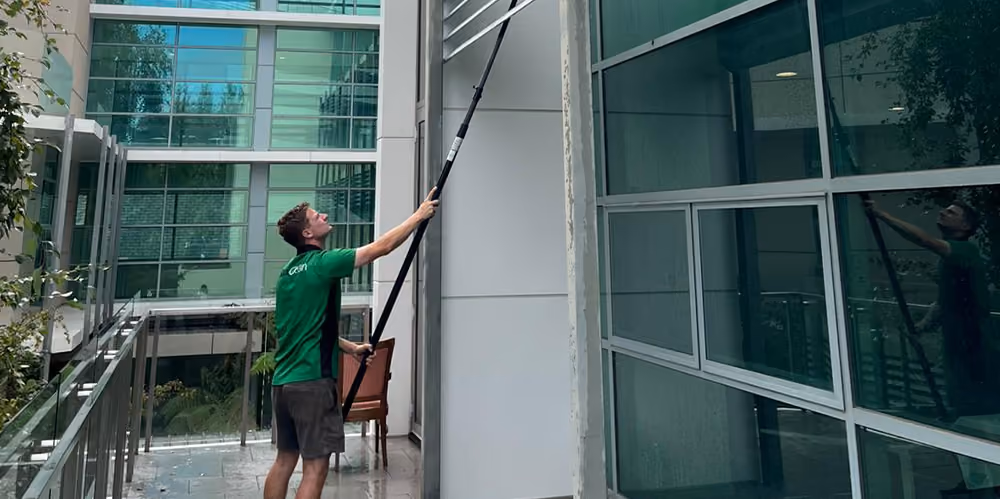 Bax Clean technician cleaning exterior windows at an aged care facility using an extendable water-fed pole system.