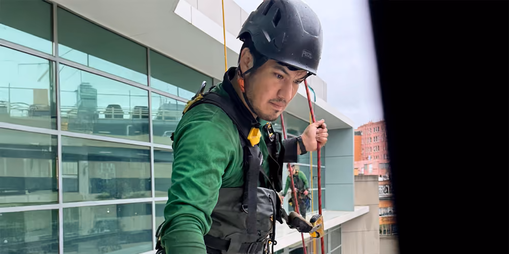 Rope access window cleaning specialist performing high-rise exterior cleaning at an aged care facility.