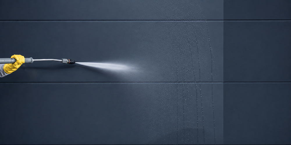 Pressure washing surface marks from a dark exterior wall at a Box Hill property.