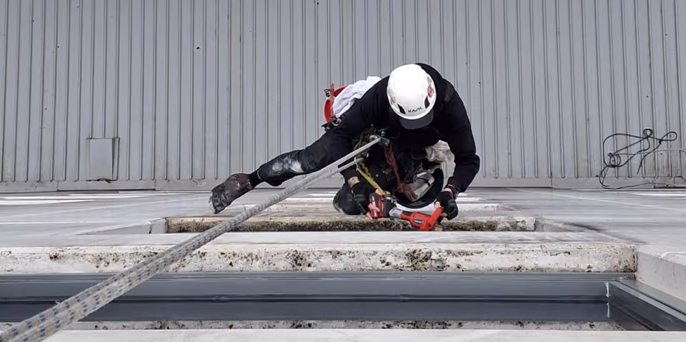 Rope access technician securing equipment before beginning exterior window cleaning at the hotel.