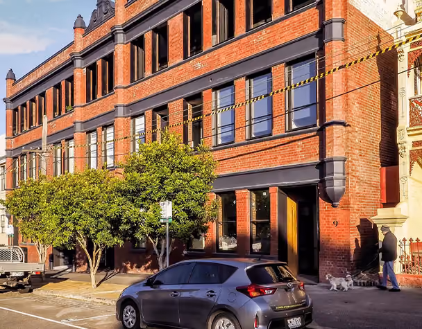 Modern residential building with timber privacy screens and large glass windows in West Melbourne.