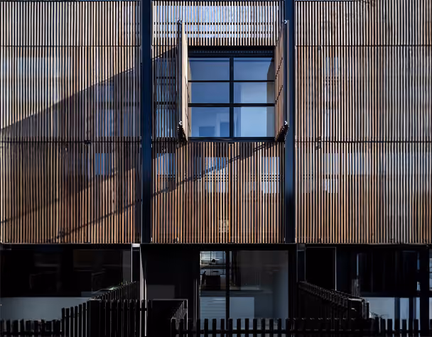 Modern residential building with timber privacy screens and large glass windows in West Melbourne.
