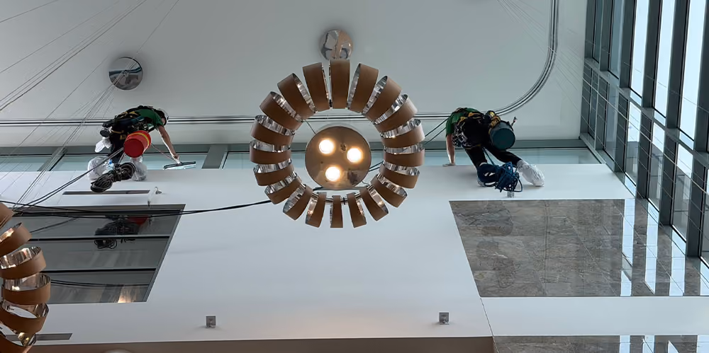 Rope access technicians performing high-level internal glass cleaning inside the retirement complex atrium.