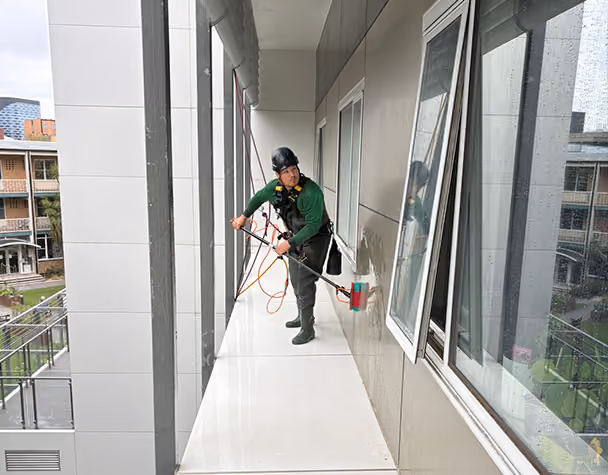 Technician cleaning exterior windows from a balcony at the premium retirement complex.