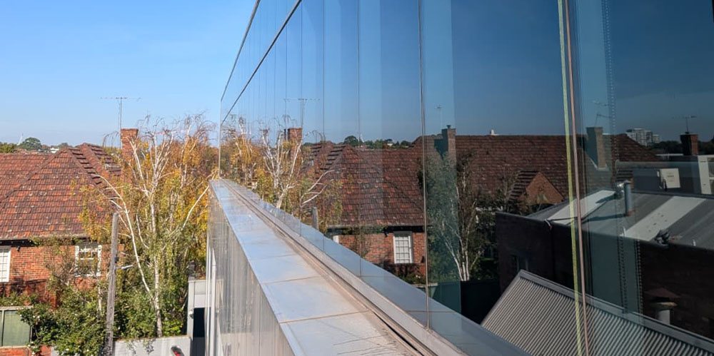 Restored glass façade and aluminium cladding following a full exterior restoration clean at a commercial building in Toorak.