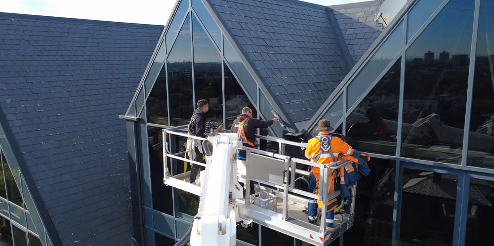 Bax Clean technicians using an elevated work platform to clean high-level windows.