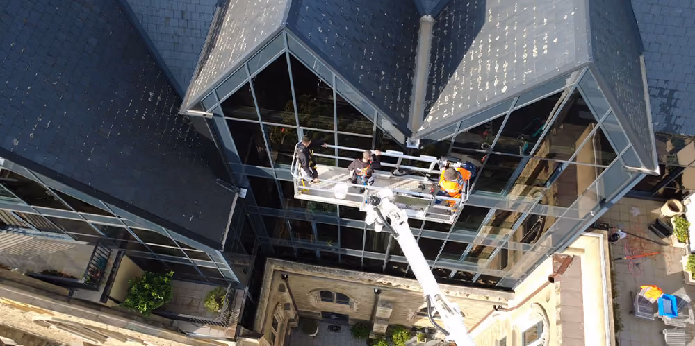 Aerial view of an elevated work platform providing access to the upper-level glass façade at the apartments.