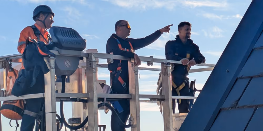 Bax Clean team inspecting upper-level glass from an elevated work platform during a project.