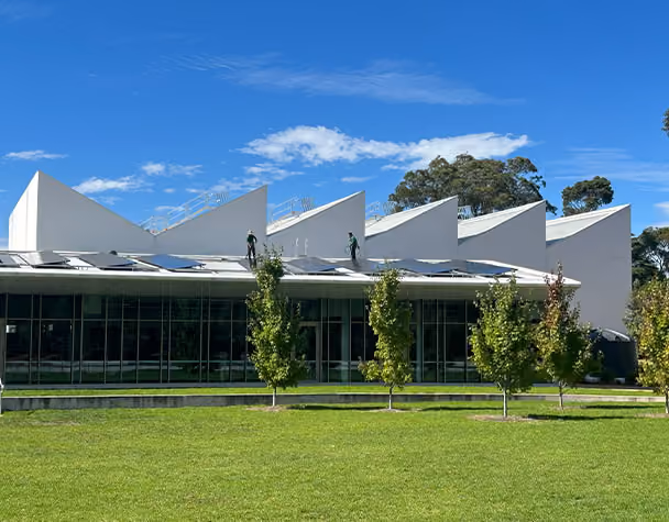 Technicians carrying out solar panel cleaning on the rooftop of a commercial building in Nunawading.