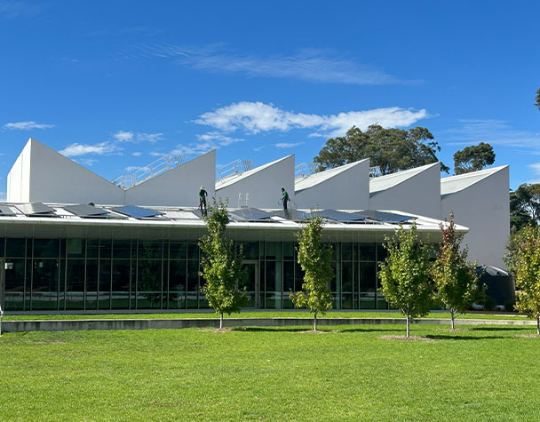 Technicians carrying out solar panel cleaning on the rooftop of a commercial building in Nunawading.