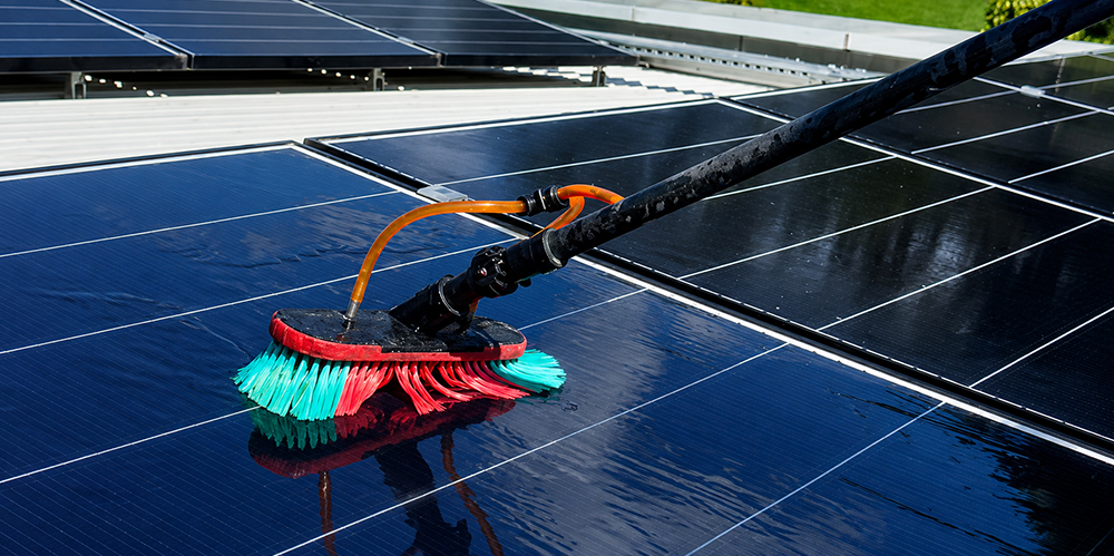 Soft-bristle brush cleaning the surface of a commercial rooftop solar panel.